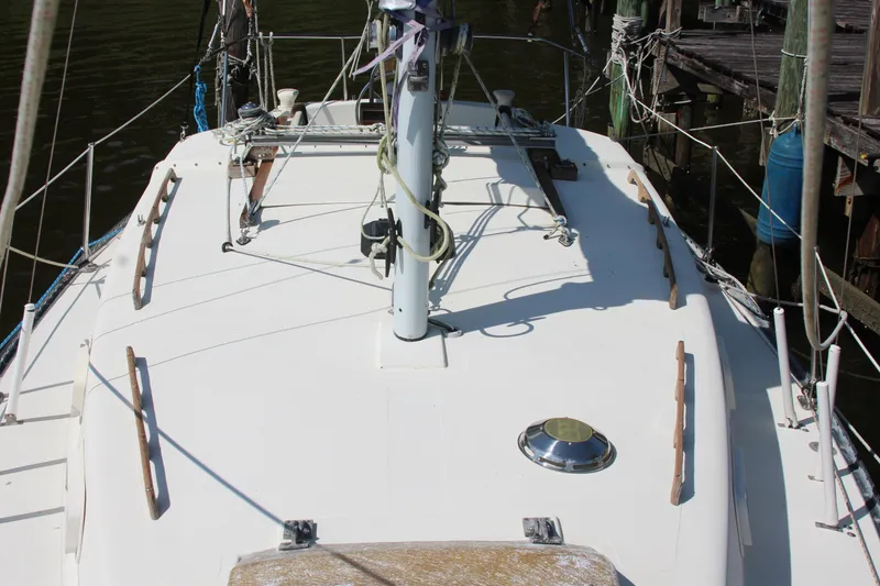 Slide: The Image of 1980 Watkins MONOHULL sailboat deck with mast and rigging, docked at a marina. - 10