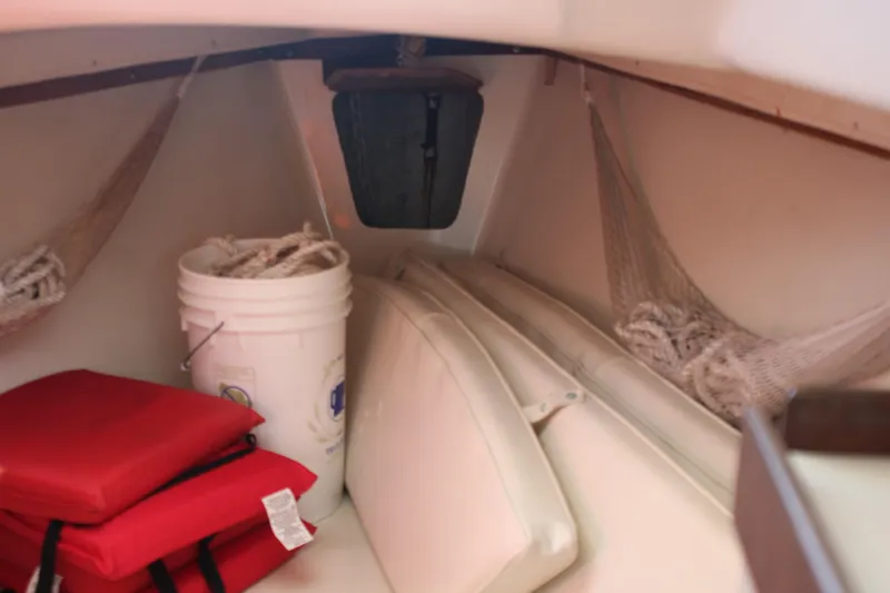 Slide: The Image of Interior of 1980 Watkins MONOHULL sailboat with red cushions and storage items. - 12