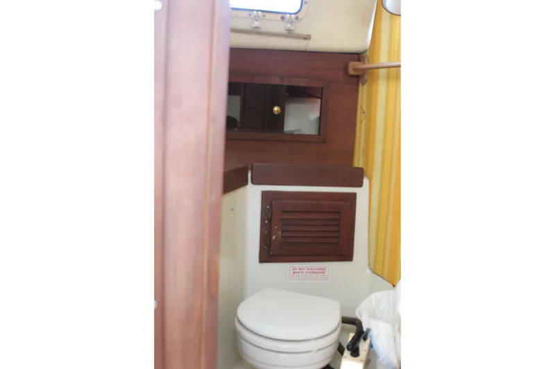 Slide: The Image of Interior of 1980 Watkins MONOHULL boat bathroom with wooden accents and yellow curtain. - 15