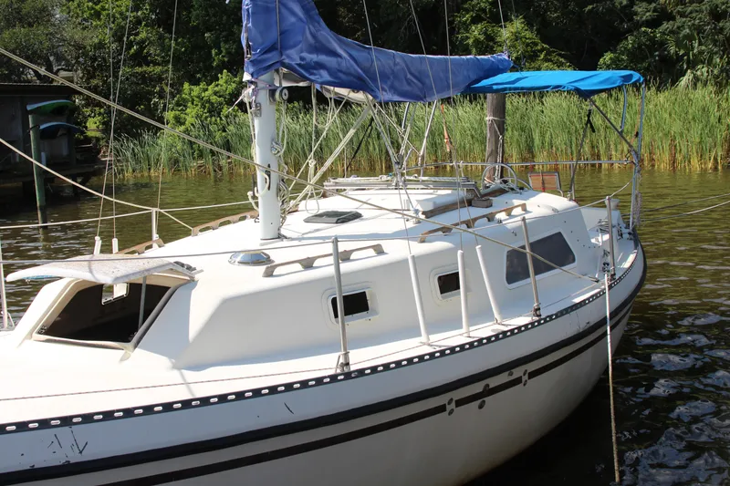Slide: The Image of 1980 Watkins MONOHULL sailboat docked by lush greenery. - 4