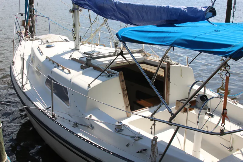 Slide: The Image of 1980 Watkins MONOHULL sailboat with blue canopy docked on calm water. - 5