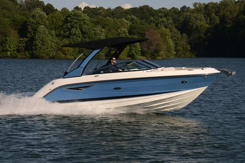 The Image of 2020 Sea Ray SLX 250 boat on trailer with blue canopy, parked outdoors. - 0