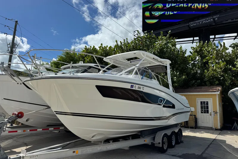 Slide: The Image of 2021 Jeanneau Leader 9.0 WA boat on trailer, parked outdoors under a clear sky. - 1