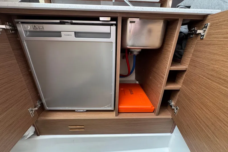 Slide: The Image of 2021 Jeanneau Leader 9.0 WA interior showing fridge, sink, and storage compartments. - 19