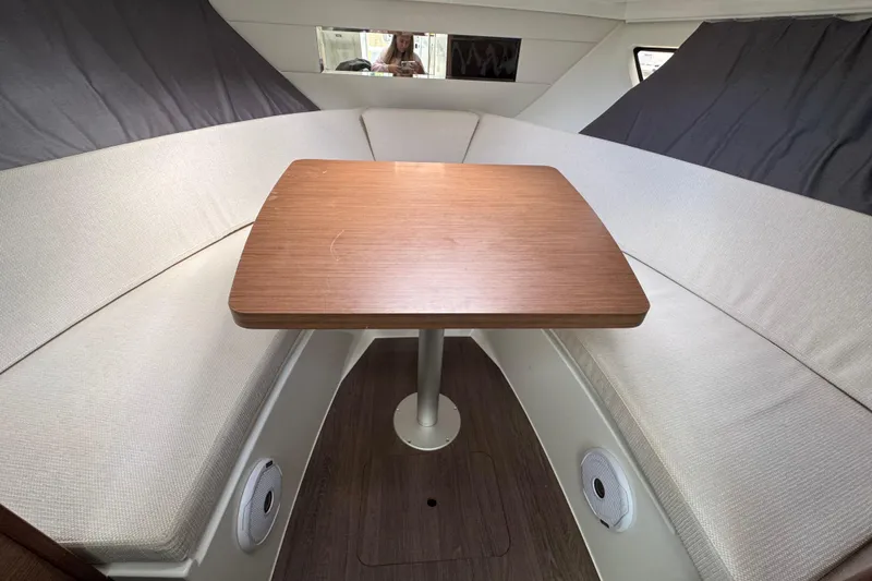 Slide: The Image of Cozy interior of 2021 Jeanneau Leader 9.0 WA with wooden table and cushioned seating. - 21