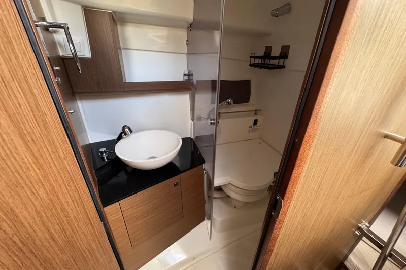 Slide: The Image of 2021 Jeanneau Leader 9.0 WA bathroom with modern sink and wooden cabinetry. - 23