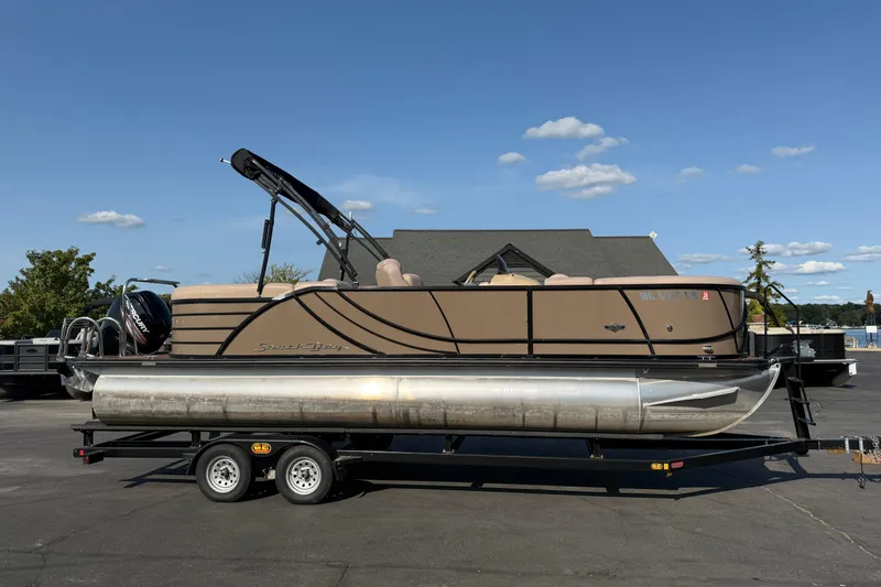 The Image of 2017 South Bay 523RS-DC pontoon boat on trailer, parked outdoors under a clear sky. - 0