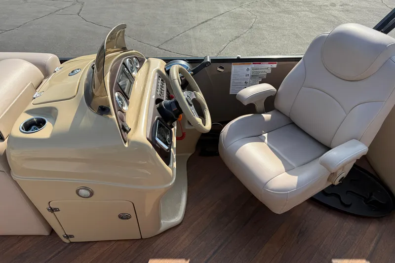 Slide: The Image of 2017 South Bay 523RS-DC boat interior with beige captain's chair and control panel. - 16
