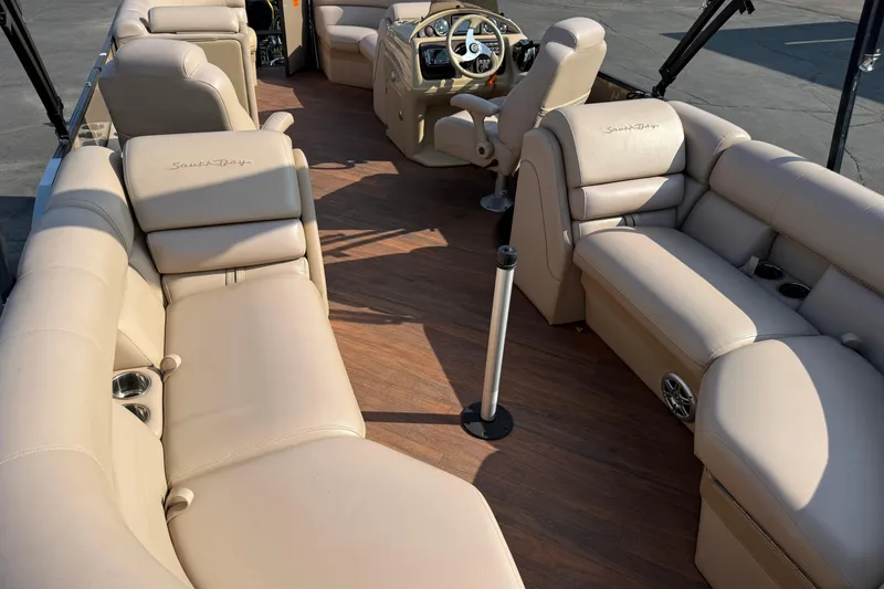 Slide: The Image of 2017 South Bay 523RS-DC pontoon boat interior with beige seating and wood flooring. - 23