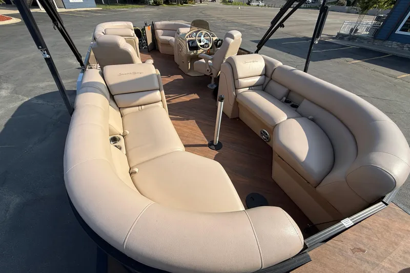 Slide: The Image of 2017 South Bay 523RS-DC pontoon boat with spacious beige seating and modern dashboard. - 24