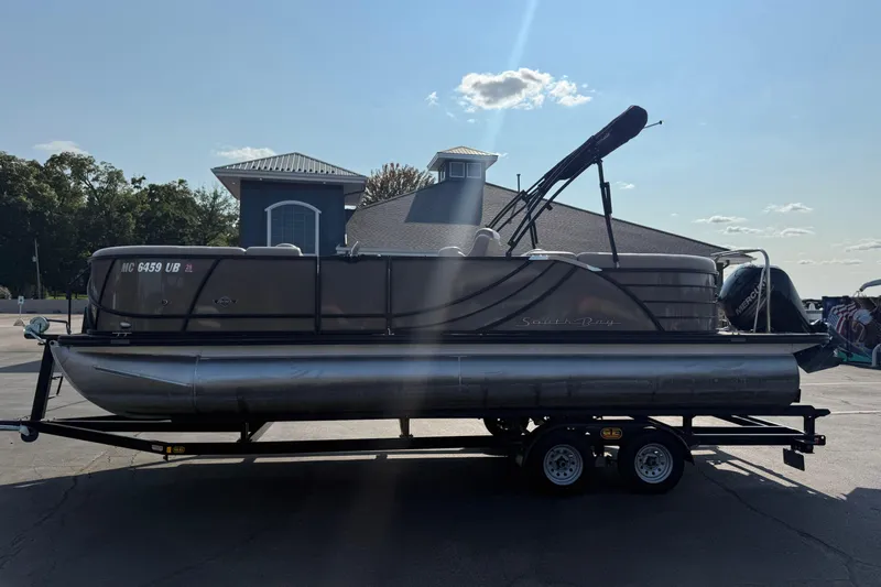 Slide: The Image of 2017 South Bay 523RS-DC pontoon boat on trailer, parked near a building. - 4