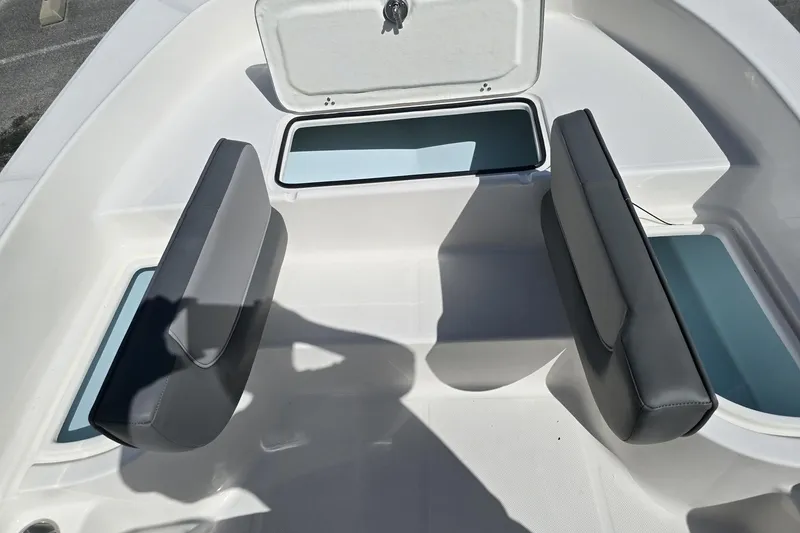 Slide: The Image of Interior of 2026 Sundance DX20 boat with cushioned seating and storage compartments. - 12