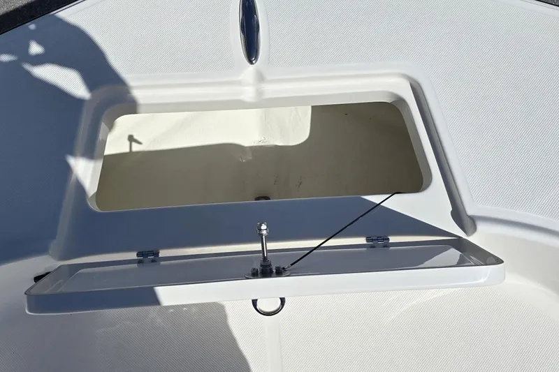 Slide: The Image of Open storage compartment on 2026 Sundance DX20 boat deck. - 14