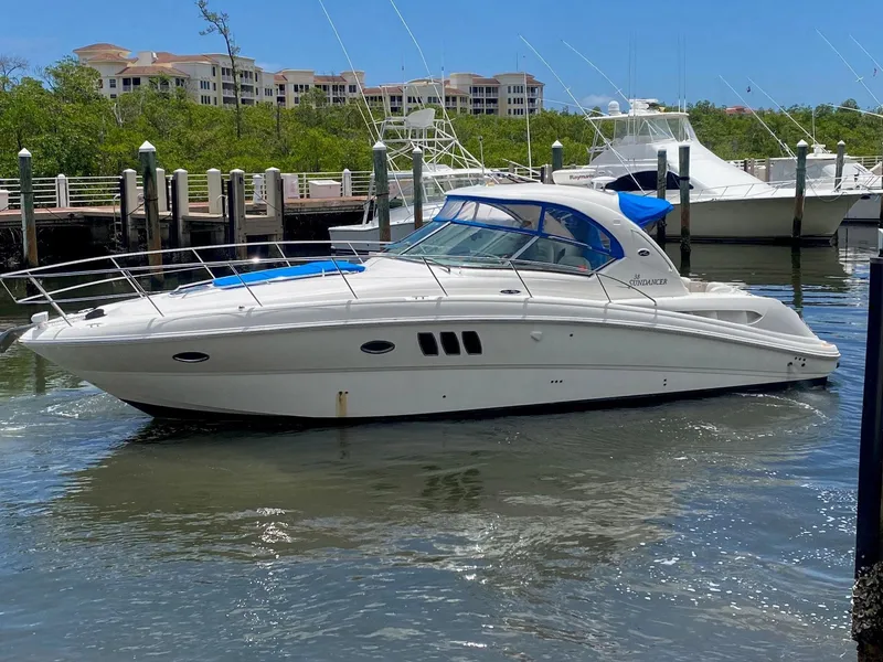 Slide: The Image of 2008 Sea Ray 38 Sundancer yacht docked in a marina, surrounded by water and buildings. - 1