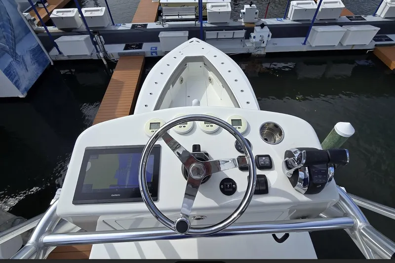 Slide: The Image of 2020 SeaVee 390Z boat helm with steering wheel and navigation controls at dock. - 24