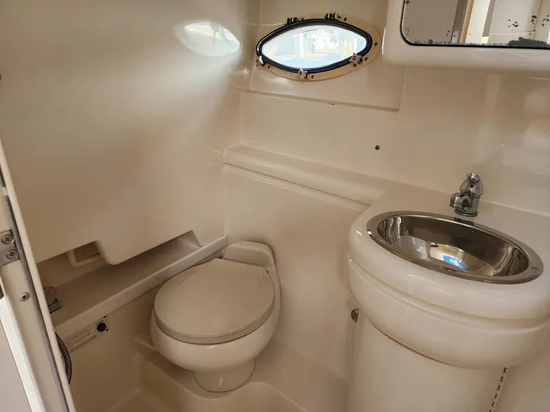 Slide: The Image of 2002 Formula 31 PC boat bathroom with toilet, sink, and porthole window. - 11