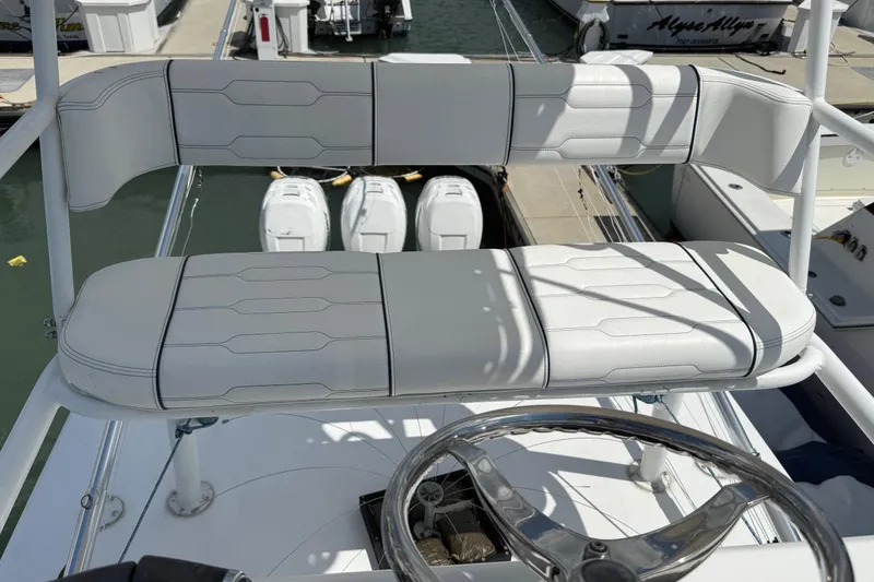 Slide: The Image of Helm seating on 2007 SeaHunter 40 boat, featuring white cushioned bench and steering wheel. - 23