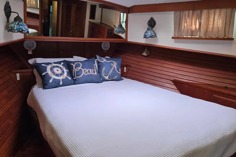 Slide: The Image of Cozy bedroom in 1997 Grand Banks 46 Europa yacht with nautical-themed pillows and wooden paneling. - 12