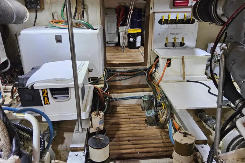 Slide: The Image of Engine room of a 1997 Grand Banks 46 Europa yacht, showcasing equipment and wiring. - 20