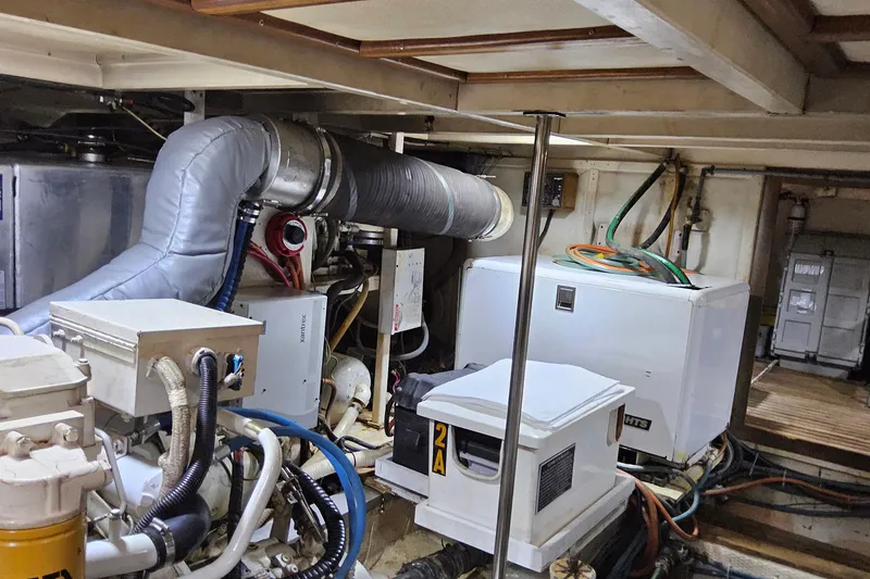 Slide: The Image of Engine room of 1997 Grand Banks 46 Europa yacht, featuring mechanical equipment and wiring. - 21