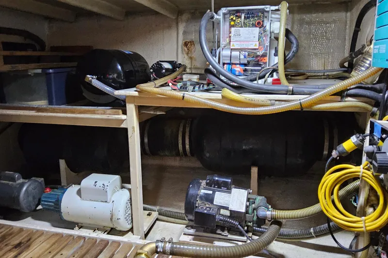 Slide: The Image of Engine room of a 1997 Grand Banks 46 Europa with various mechanical components and hoses. - 22