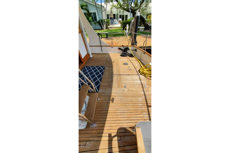 Slide: The Image of Teak deck of 1997 Grand Banks 46 Europa yacht with outdoor seating and coiled hose. - 23