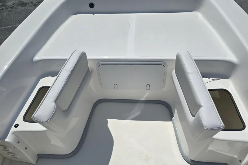 Slide: The Image of 2026 Sundance B22CCR boat interior with white cushioned seating and storage compartments. - 11