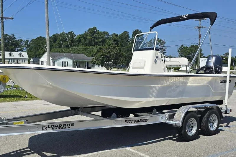 Slide: The Image of 2026 Sundance B22CCR boat on Load Rite trailer, parked outdoors. - 12