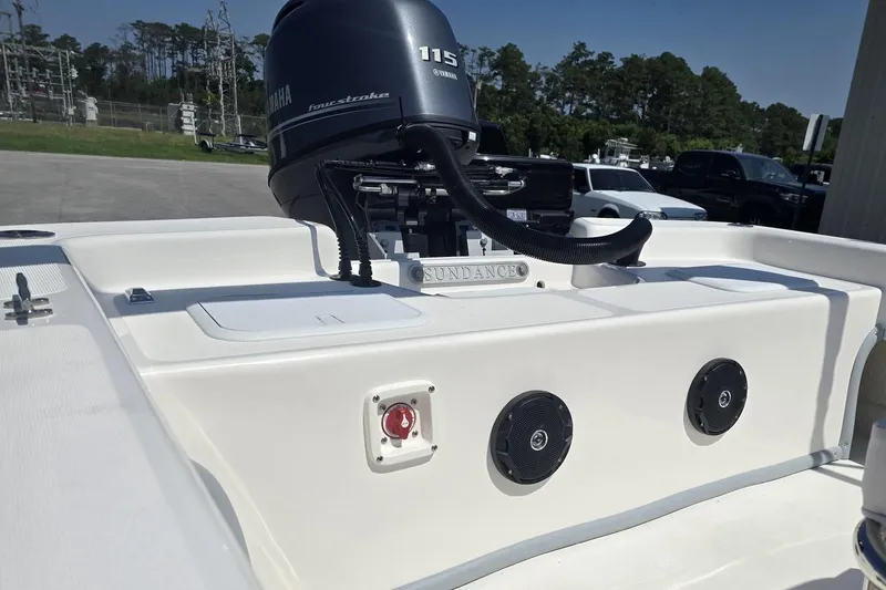 Slide: The Image of 2026 Sundance B22CCR boat with Yamaha 115 four-stroke engine, parked outdoors. - 3