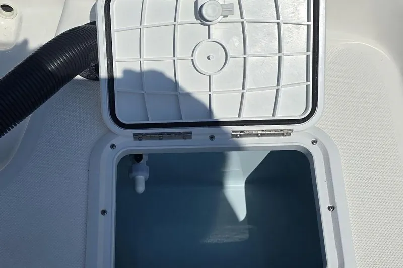 Slide: The Image of Open storage compartment on 2026 Sundance B22CCR boat, featuring a hinged lid and interior view. - 4