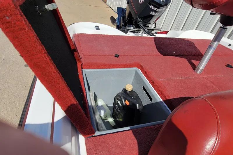 Slide: The Image of Open storage compartment on 2000 Nitro 640LX boat with red carpet and engine in background. - 11