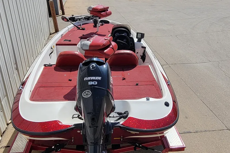 Slide: The Image of 2000 Nitro 640LX boat with Evinrude 90 engine, red and white design, parked outdoors. - 15