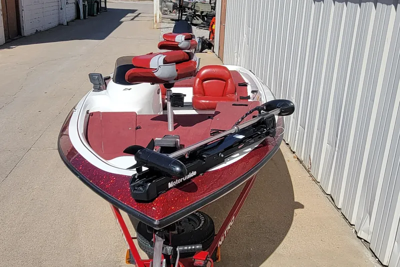 Slide: The Image of 2000 Nitro 640LX boat with red and white seats, parked outdoors. - 18