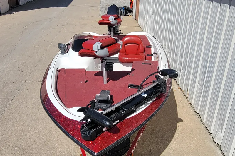 Slide: The Image of 2000 Nitro 640LX boat with red and white seating, parked beside a building. - 19
