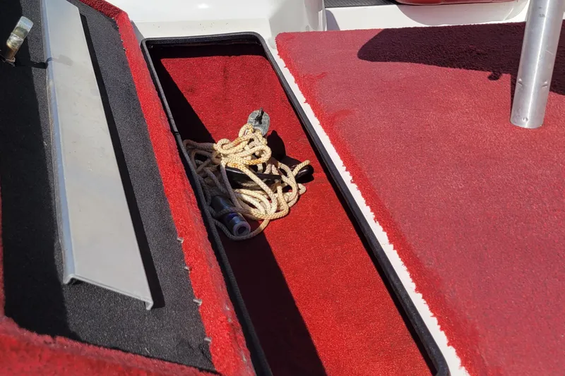 Slide: The Image of Open storage compartment on 2000 Nitro 640LX boat with red carpet and rope inside. - 20