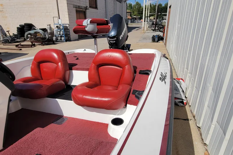 Slide: The Image of 2000 Nitro 640LX boat with red seats and Evinrude motor, docked outdoors. - 28
