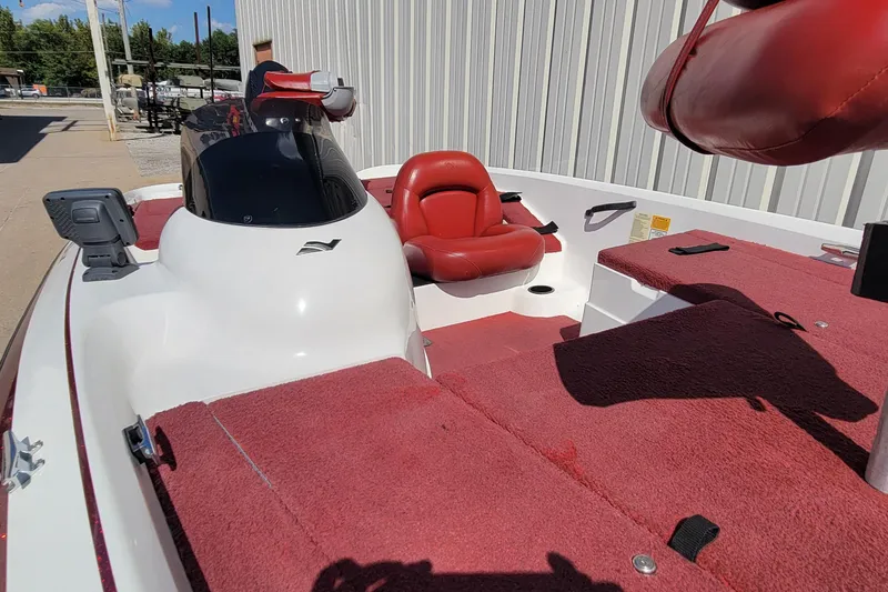 Slide: The Image of 2000 Nitro 640LX boat with red interior and white exterior, docked outdoors. - 29