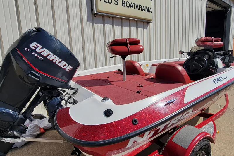 Slide: The Image of Red and white 2000 Nitro 640LX boat with Evinrude motor at dealership. - 38