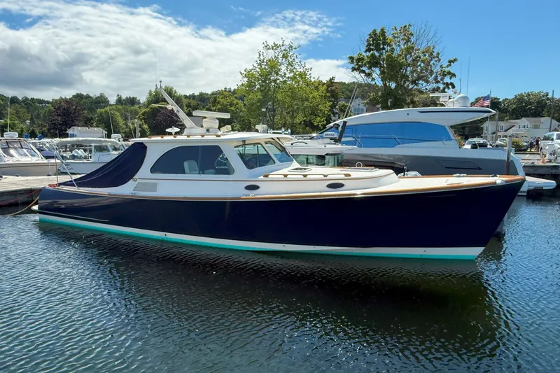 The Image of 2003 Hinckley Talaria 40 yacht docked in a marina under a clear blue sky. - 0