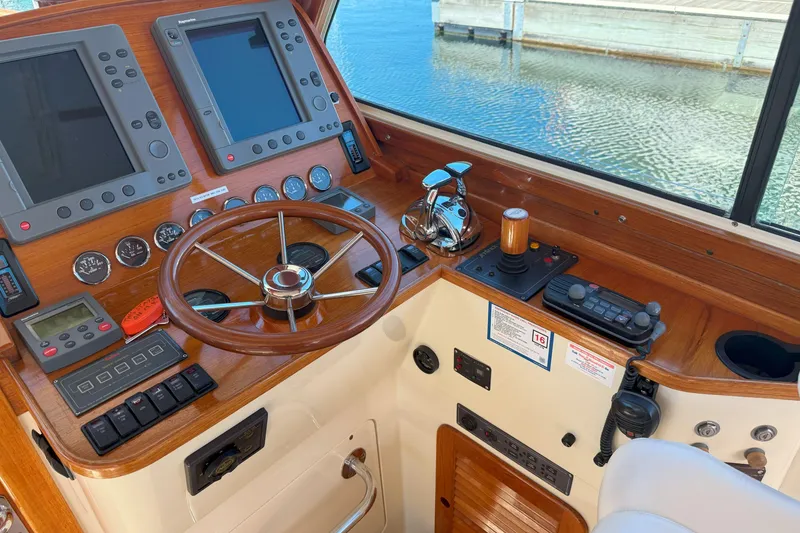 Slide: The Image of Helm of 2003 Hinckley Talaria 40 with wooden steering wheel and navigation controls. - 10