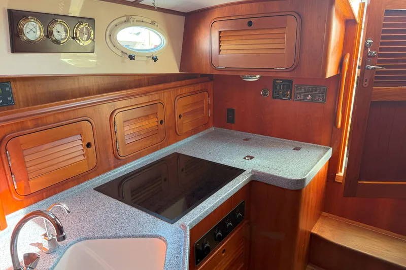 Slide: The Image of Hinckley Talaria 40 yacht kitchen, 2003 model, featuring wooden cabinetry and modern appliances. - 14