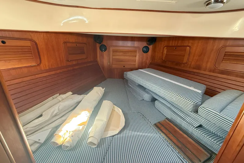 Slide: The Image of Interior cabin of 2003 Hinckley Talaria 40 with striped cushions and wooden paneling. - 15