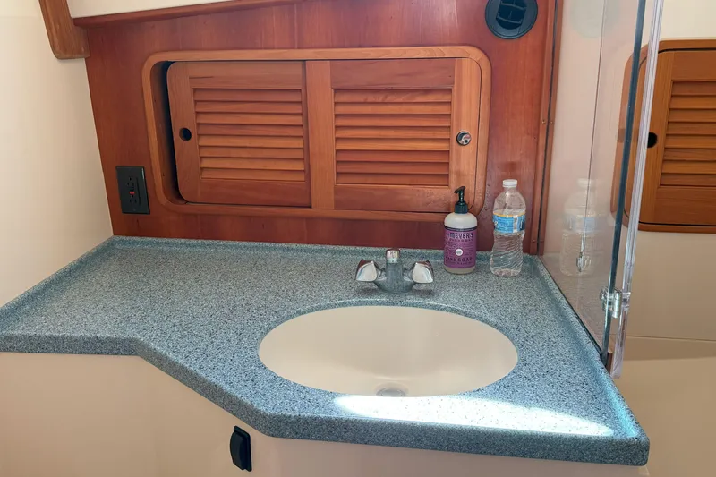 Slide: The Image of Hinckley Talaria 40 (2003) bathroom sink with wooden cabinet and countertop accessories. - 17