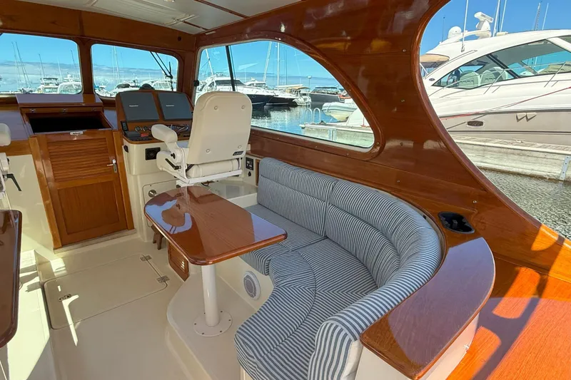 Slide: The Image of Interior of 2003 Hinckley Talaria 40 yacht with wood finish and striped seating. - 3