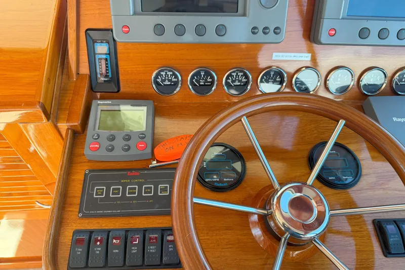 Slide: The Image of Hinckley Talaria 40 yacht dashboard with wooden steering wheel and navigation instruments, 2003 model. - 11