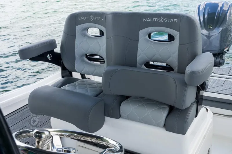 Slide: The Image of 2026 NauticStar 251 Hybrid boat seats with gray upholstery and armrests, on water. - 12