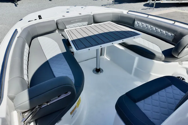 Slide: The Image of 2026 NauticStar 251 Hybrid boat interior with gray seating and central table. - 19