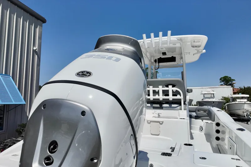 Slide: The Image of 2026 NauticStar 251 Hybrid boat with powerful engine, docked under clear blue sky. - 21