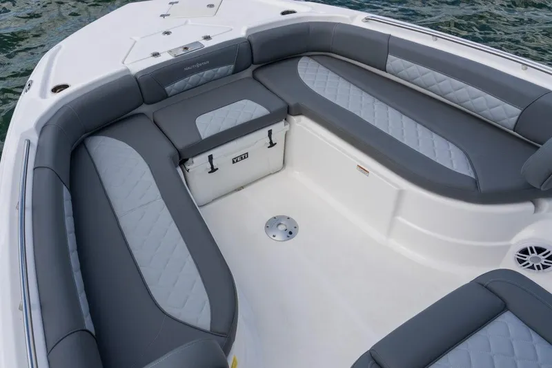 Slide: The Image of 2026 NauticStar 251 Hybrid boat interior with gray cushioned seating and Yeti cooler. - 6