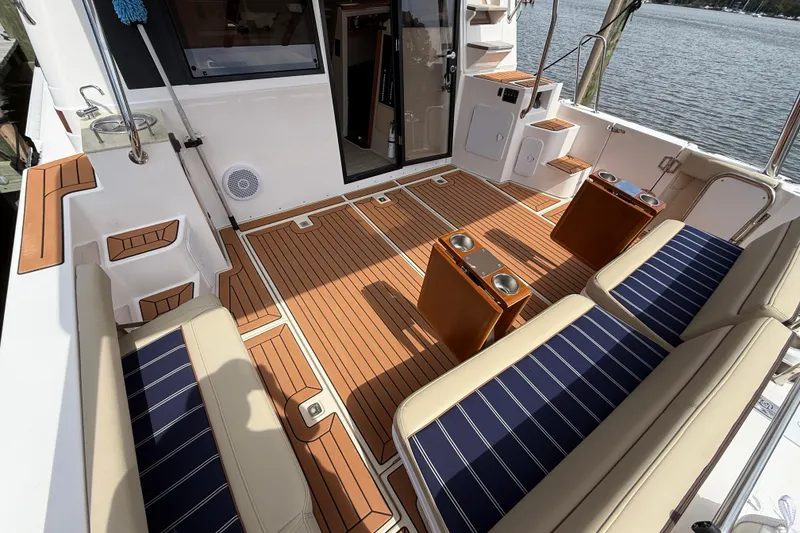 Slide: The Image of 2021 Ranger Tugs R-41CB boat deck with seating and cup holders, docked by water. - 10